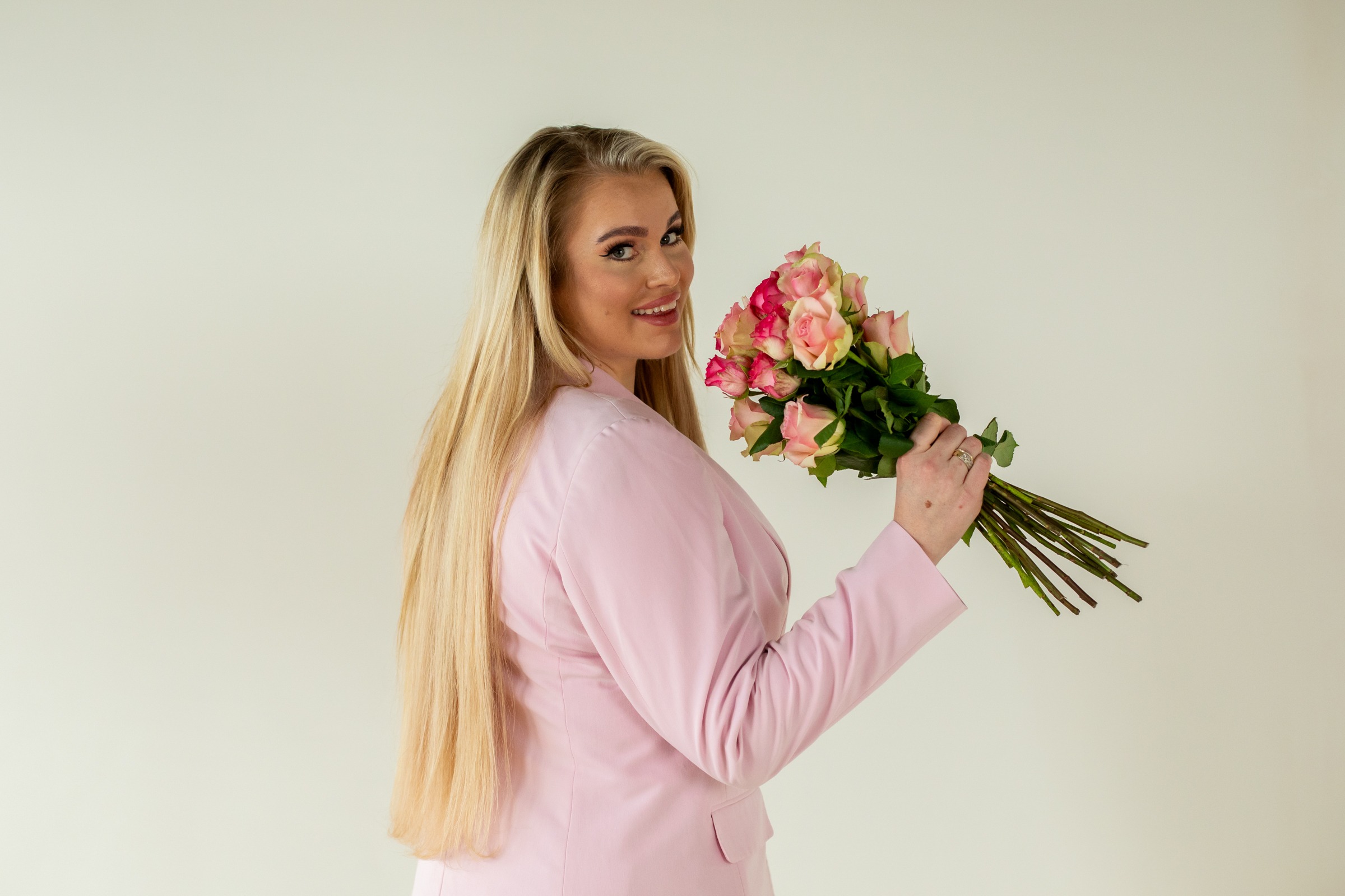 vrouw met roze rozen en roze pak